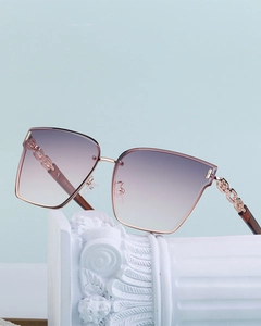 Detail of rose gold chain-link temple design on fashionable oversized women's sunglasses