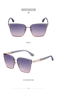 Detail view of large frame sunglasses with gradient lenses and chain temple design