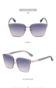 Detail view of large frame sunglasses with metal chain temples and grey gradient lenses