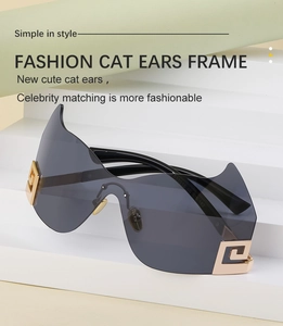 Detail der übergroßen randlosen Sonnenbrille mit grauen Katzenohr-Gläsern und Goldakzenten