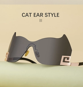 Details einer katzenohr-randlosen Sonnenbrille mit grauen Gläsern und goldener Verzierung