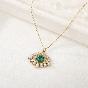 Vue détaillée du pendentif œil porte-bonheur doré avec malachite et zircons étincelants