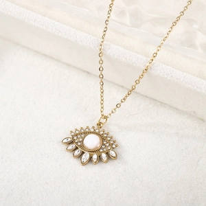 Détail macro d'un collier œil maléfique doré avec opale et cristaux étincelants