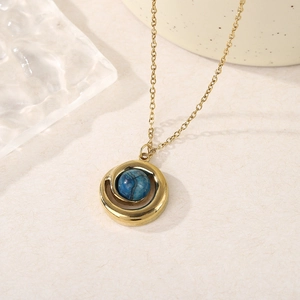 Détail macro du collier doré avec pendentif serti d'une pierre naturelle bleue ronde