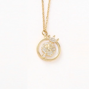 Détail du collier à pendentif rond avec un ours à couronne dorée et cristaux blancs