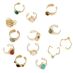 Ensemble de bagues dorées bohèmes serties de turquoise et de quartz sur fond blanc