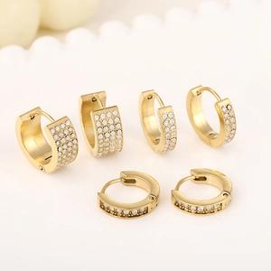 Detail of three pairs of gold-plated stainless steel earrings with sparkling white crystals