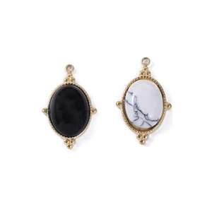 Vue détaillée de pendentifs ovales en pierre noire et marbre blanc avec cadre doré perlé