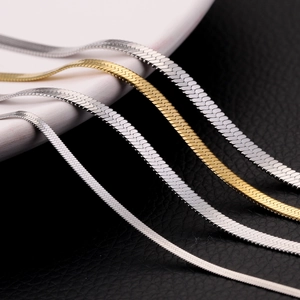 Minimalist gold and silver stainless steel flat snake chains on a black and white background