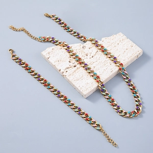 Golden Cuban link chain jewelry set with colorful enamel charms on light gray background