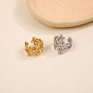 Minimalist cutout daisy open rings in gold and silver finishes on a matte surface