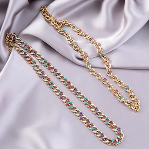Colorful enamel-drip gold chain bracelet set on soft purple silk fabric background