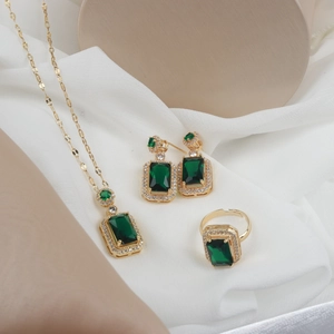 Vintage emerald green jewelry set with necklace earrings and ring on silk background