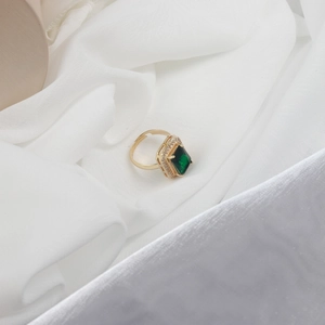 Detailed shot of emerald cut ring with zircon halo and adjustable gold-plated band