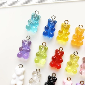 Macro shot of colorful resin gummy bear charms with metal hooks for DIY jewelry making