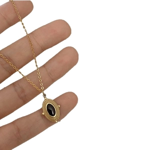 French retro gold titanium steel necklace with black oval stone pendant and sunburst detail