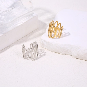 Detailed view of hollow wavy gold and silver titanium rings on minimalist pedestals
