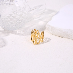 Detailed view of an irregular hollow gold ring on white textured sand backdrop