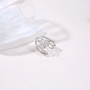 Close-up of silver hollowed irregular line pattern ring on matte white background