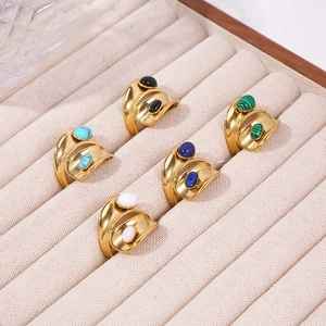 Macro view of vintage gold layered wave rings featuring diverse oval gemstone inlays