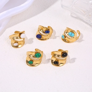 Macro view of wide double-layer gold rings with various inlaid oval gemstones