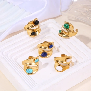 Detailed view of five adjustable gold rings set with colorful oval synthetic stones