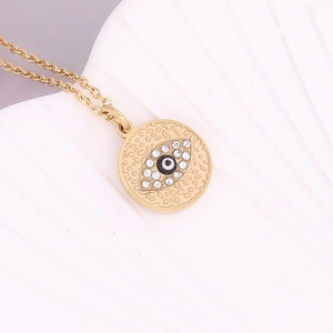 Λεπτομέρεια του χρυσού μενταγιόν evil eye με λευκή πέρλα και λαμπερά κρύσταλλα