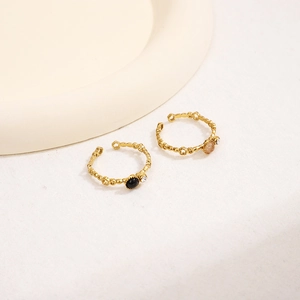 Elegant gold flower hollow rings with champagne and black stones on white tray