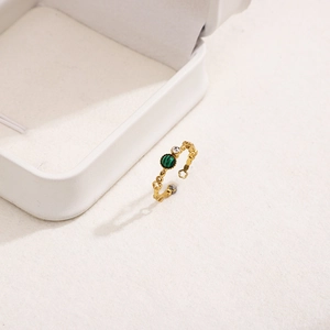Macro detail of French style ring with green stone, white zircon and hollow band
