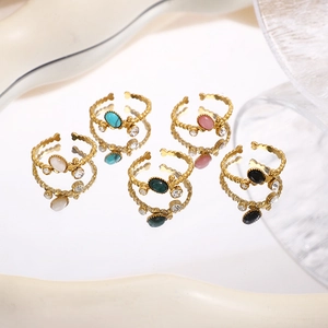 Set of five gold-plated oval natural stone rings with beaded texture and adjustable bands