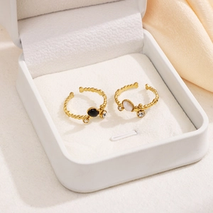 Set of two gold stainless steel rings with black and white gemstones in a gift box