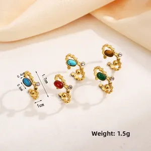 Détail de boucles d'oreilles vintage dorées avec pierres naturelles et zircons