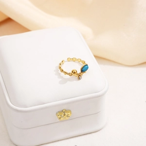 Détail de la bague vintage dorée avec pierre ovale bleue et zircon scintillant