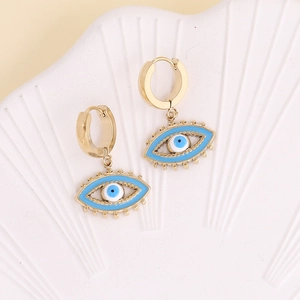 Golden Nazar evil eye hoop earrings with blue enamel charms on a shell display