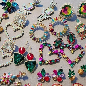Macro display of large colorful zircon earrings with various vintage floral and geometric patterns