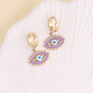 Chic gold-plated hoop earrings with purple enamel evil eye charms on a decorative tray