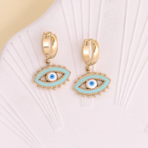 Detailed view of gold Evil Eye earrings with blue enamel on white textured background