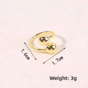 Detailed size view of a gold open ring with dual spheres measuring 1.6cm by 1.7cm