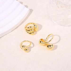 Three gold fluid geometric adjustable rings on sand and glass decor for summer