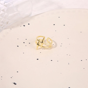 Macro detail of gold plated adjustable ring with star design on ceramic tray