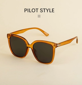 Detail view of amber pilot sunglasses featuring polarized lenses and metal hinge accents