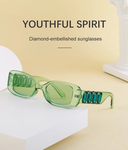 Détail de lunettes de soleil carrées vert clair serties de gemmes sur socles blancs