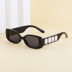 Détail de lunettes de soleil carrées de luxe avec grands strass sur les branches