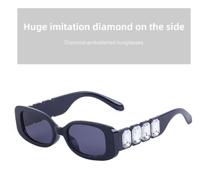 Détail de lunettes de soleil rétro noires avec de grands cristaux rectangulaires sur les branches