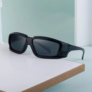 Detail view of black wrap-around sporty sunglasses on a minimalist display stand