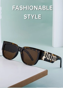 Détail de lunettes de soleil écaillées avec logo Palm gothique doré sur les branches