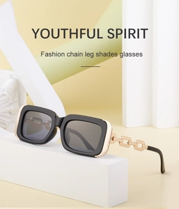 Detail of black square sunglasses featuring a luxury gold metal chain temple design