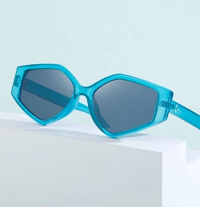 Detailed view of blue polygonal sunglasses with metal rivets on a geometric stand