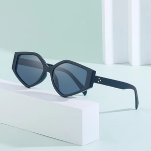 Detail of matte black polygonal sunglasses featuring triple gold triangle rivets