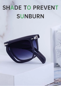 Close-up of foldable sunglasses with silver spike studs and blue gradient lenses